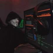 Hacker wearing a black jacket and a mask.