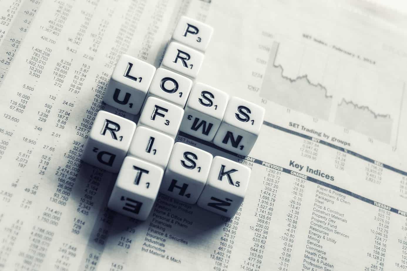 White cubes forming the words profit, loss, and risk.