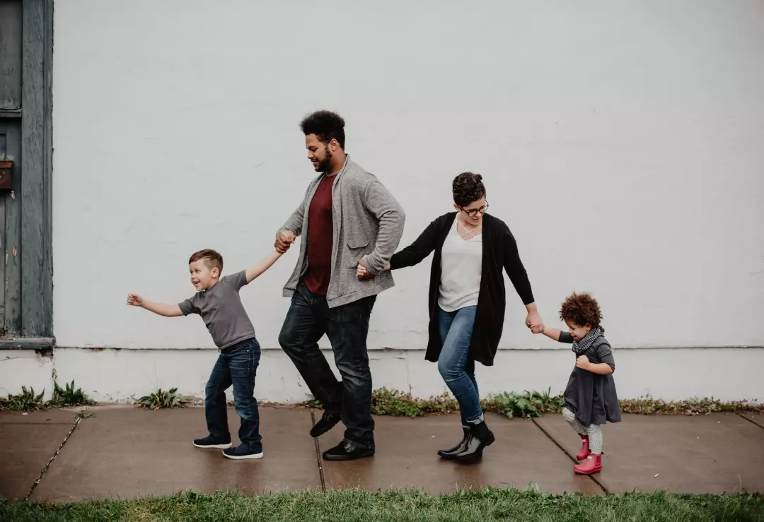 A family of four with little children walking together.