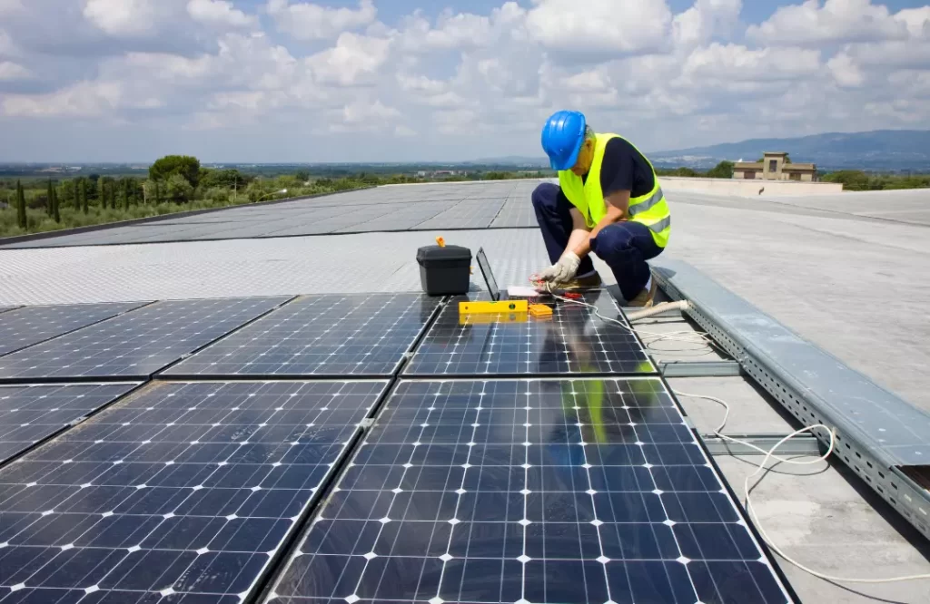 A trades person installing solar panels.