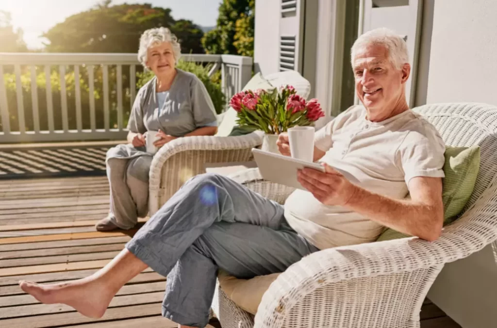 An elderly couple enjoying the sun in their house's terrace.