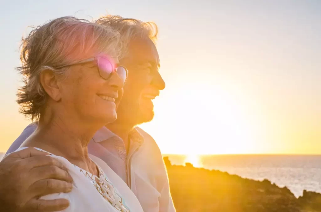Elderly couple enjoying the sunset on the sea.