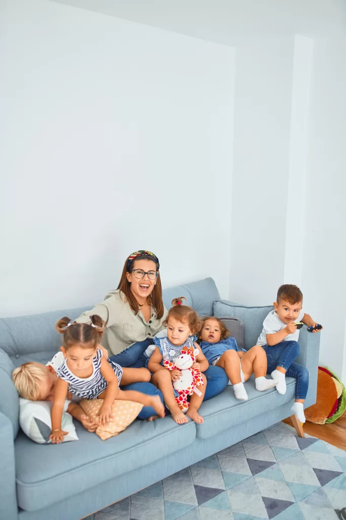 A woman with little kids on the couch.