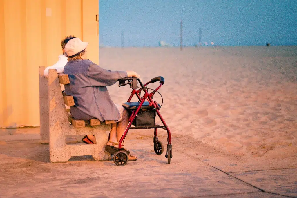 An old couple sitting together near the beach.