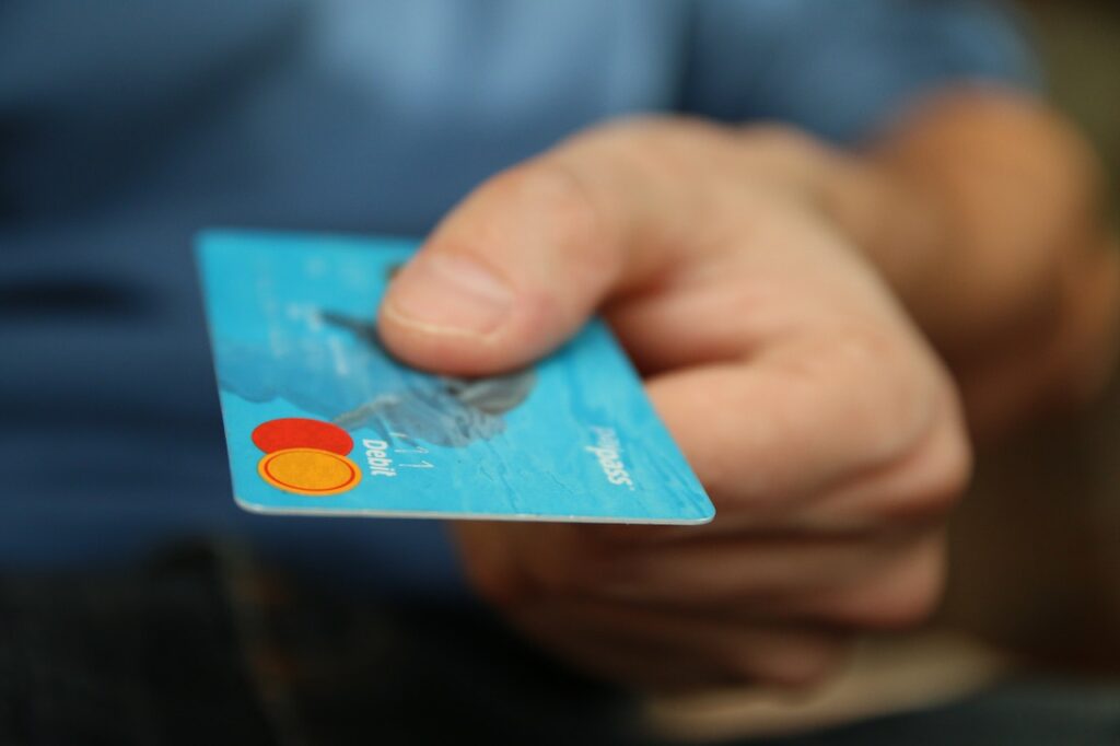 Person giving a blue credit card.