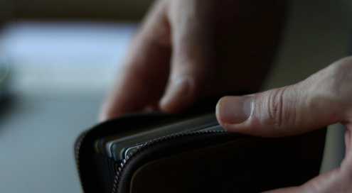 A person looking at a wallet.