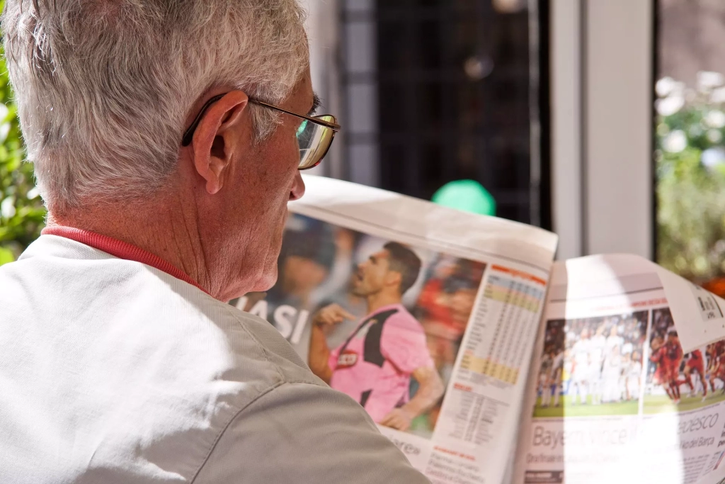 An old man reading a newspaper.