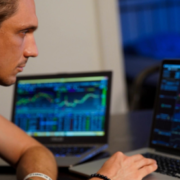 Man using laptop to monitor trading.