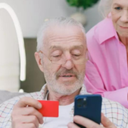 Senior couple using a card for online transaction.
