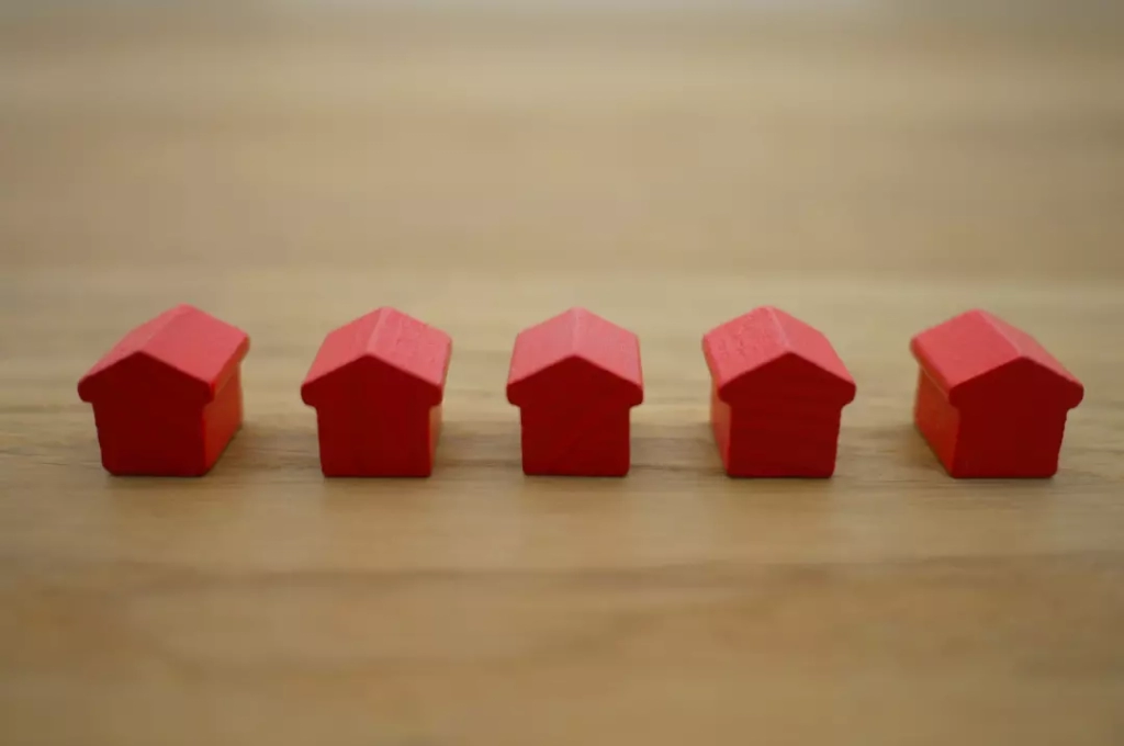 Five tiny wooden red houses.