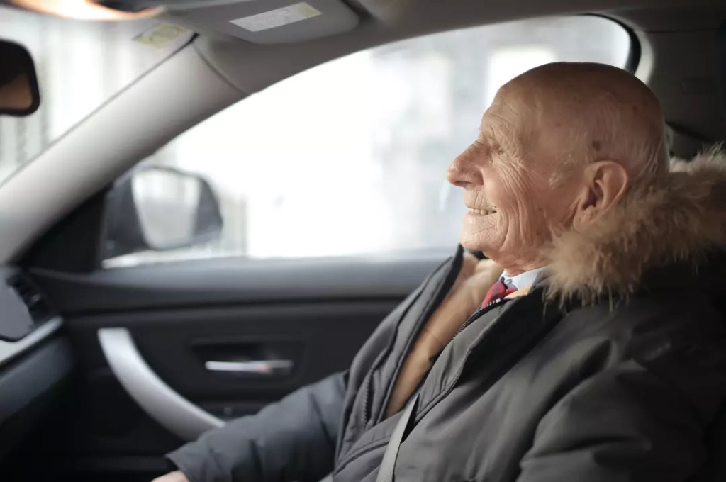 Smiling senior man inside a car.