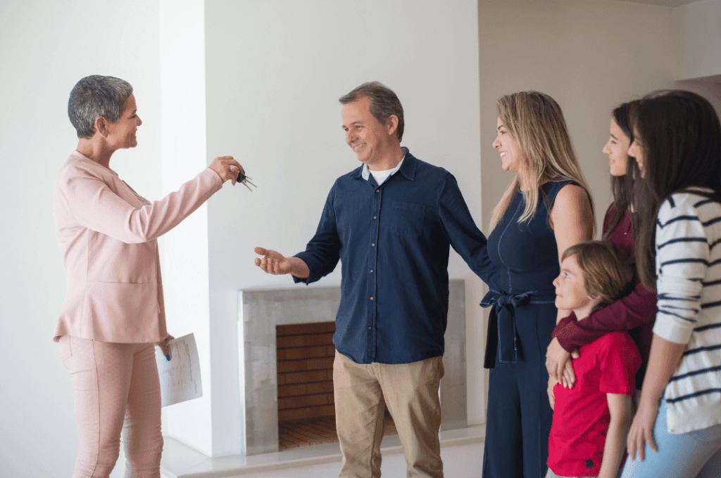 A real estate agent handing the keys to the happy family.