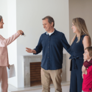A real estate agent handing the keys to the happy family.