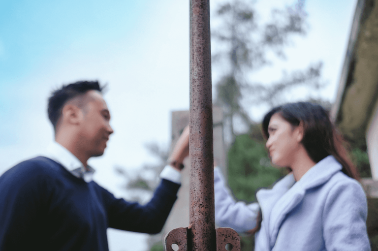 Pole in the middle of a couple holding hands.