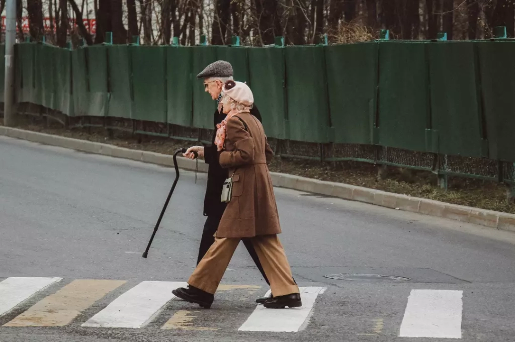 Senior couple walking on the pedestrian lane.