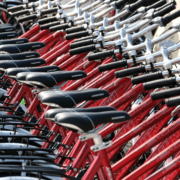 A row of red bicycles for rent.