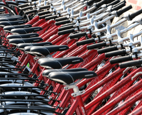 A row of red bicycles for rent.