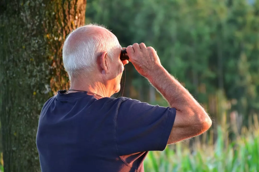 Old man using binoculars.