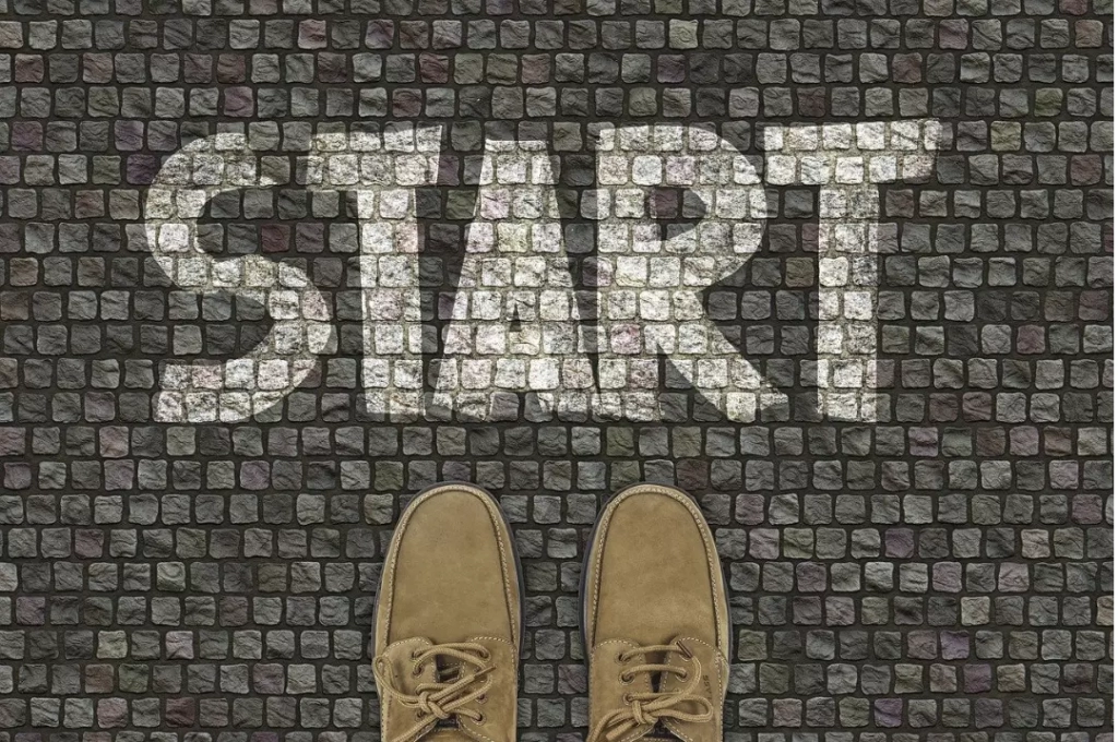 A person standing on a pavement that says start.