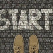 A person standing on a pavement that says start.
