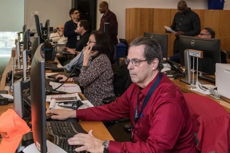 Man in red long sleeves using a computer.