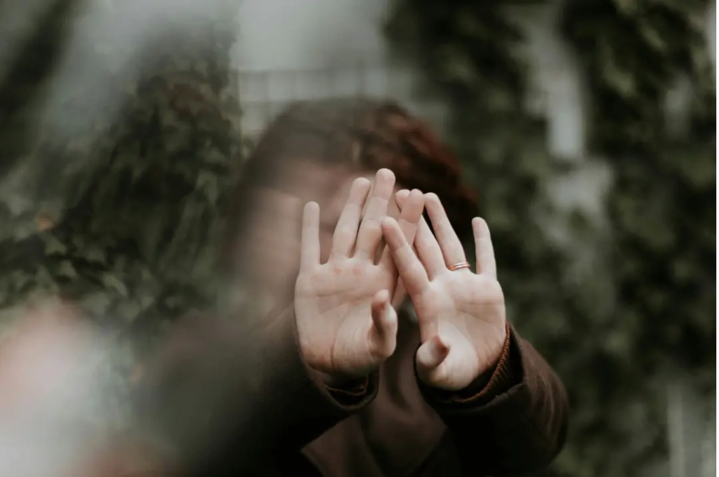 Woman covering her face with her hands.